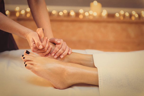Skillful beautician undergoing feet massage - Foto, afbeelding