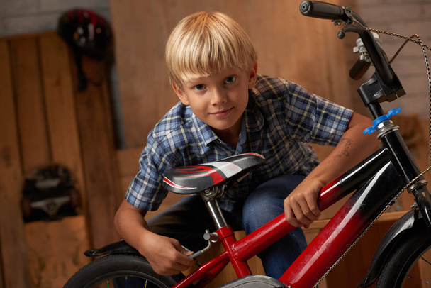Boy adjusting bicycle seat - Foto, Bild
