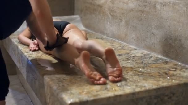 Uma jovem deitada no estômago, relaxando e desfrutando do banho turco
 - Filmagem, Vídeo
