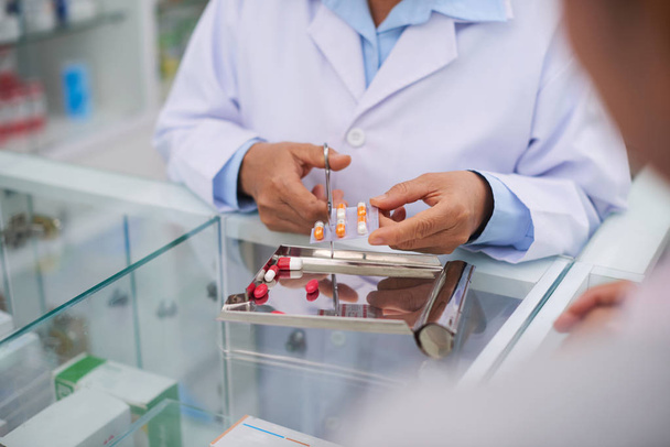 Pharmacist cutting package of pills  - Photo, Image