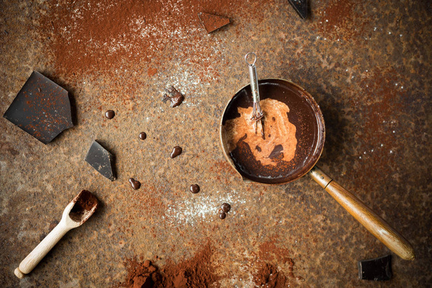 Homemade hot chocolate with milk, chocolate drops and cocoa powder on rustic background. Making chocolate. - Foto, Imagen