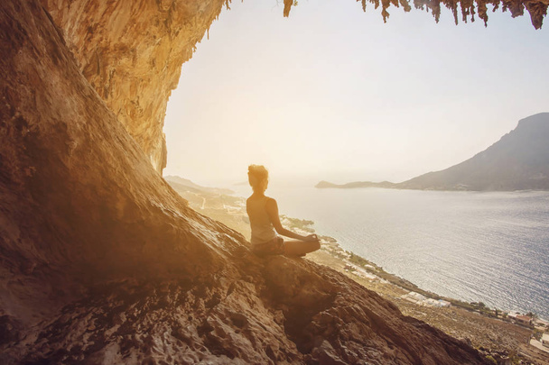 Nainen meditoi Telendosin saarta vastaan auringonlaskun aikaan.
 - Valokuva, kuva