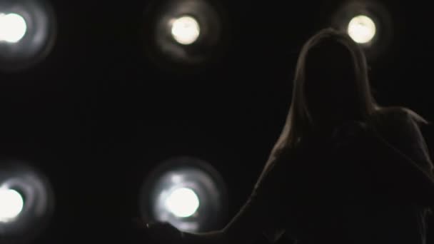 Silhouette d'une fille dansant sur les lumières de fond. Mouvement lent
 - Séquence, vidéo