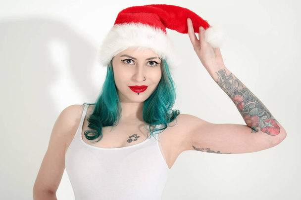 Beautiful young woman in red Christmas hat  - Photo, image