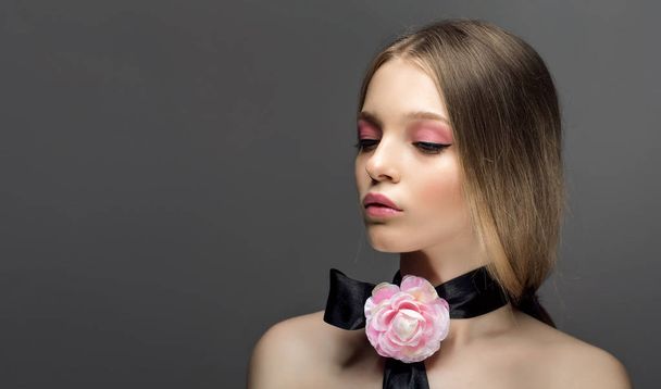 Portrait of young beautiful healthy woman with fancy pink rose o - Zdjęcie, obraz