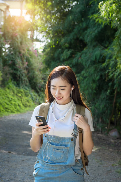 Fiatal ázsiai hipster visel fejhallgató hallgat zenét keresztül sm - Fotó, kép
