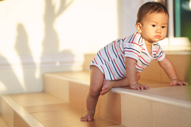 10 kuukautta ihana aasialainen vauva kiipeily alas portaita
 - Valokuva, kuva