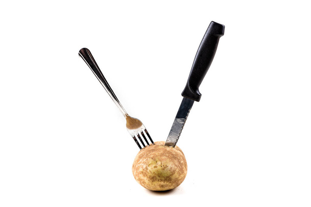 Uma batata apunhalada com uma faca e um garfo
 - Foto, Imagem