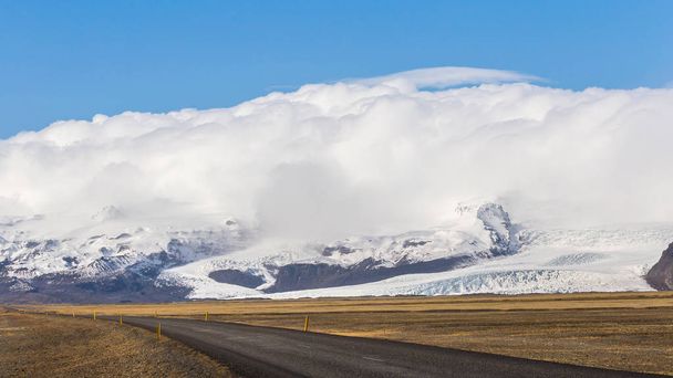 Straße vorbei am Vatnajokull-Gletscher in Südisland, bedeckt von Eis, Schnee und Wolken - Foto, Bild