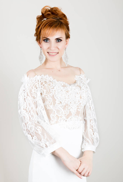 Beautiful young redhead bride wearing white wedding dress with professional make-up and hairstyle - Foto, Imagem
