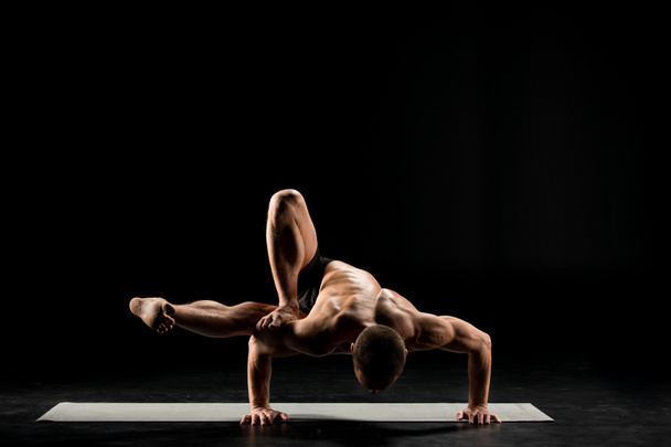 Man die in de positie van de yoga - Foto, afbeelding