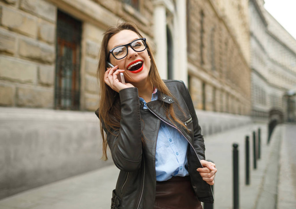 Businesswoman walking down the street while talking on smart pho - Foto, Bild