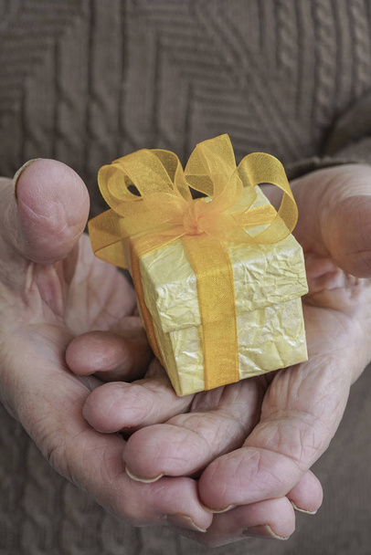 Wrinkled hands holding a gift - Photo, Image