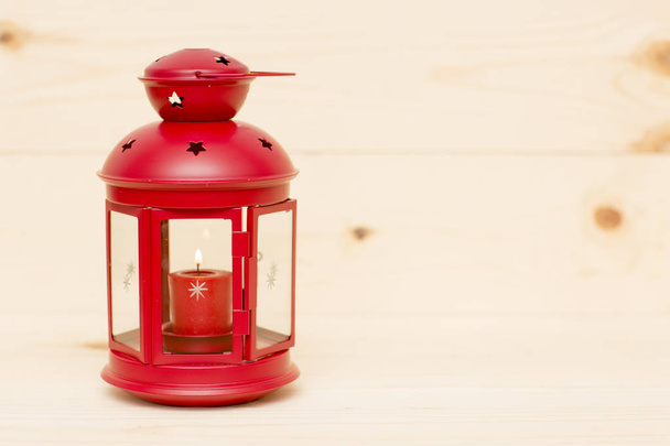 Красный металлический фонарь с горящей свечой
. - Фото, изображение
