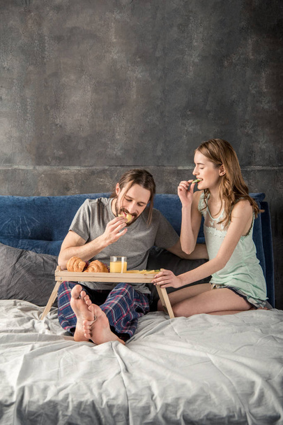 Couple prend le petit déjeuner au lit
 - Photo, image