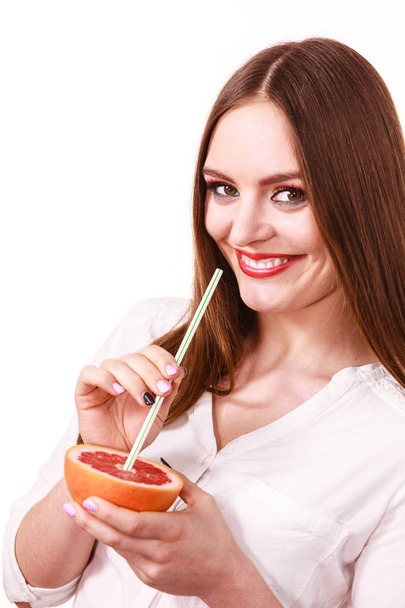 Woman holds grapefruit drinking juice from fruit - Photo, image