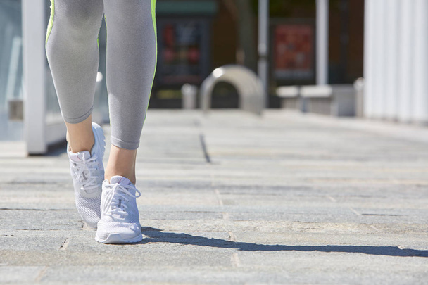 Woman with sport shoes and tracksuit in the city, summer  - Foto, Imagem