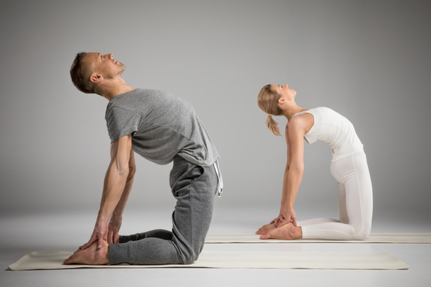 Couple debout dans la pose de yoga
   - Photo, image