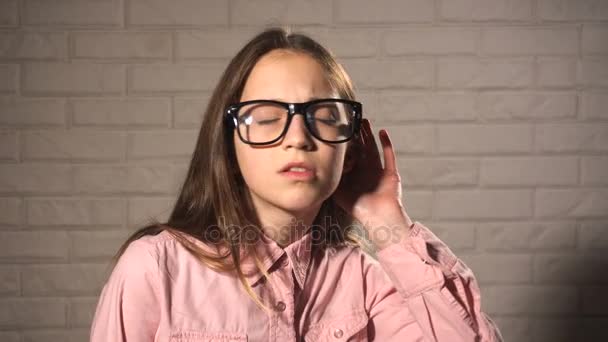 Teen dziewczyna stara się usłyszeć coś - Materiał filmowy, wideo