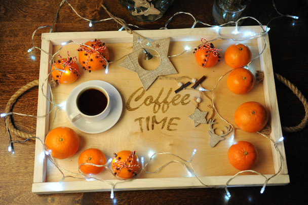 Mandarynki, Kawa, dekoracji i garland na drewnianej tacy z wygrawerowanym "coffee time". Atmosferę podczas świąt, wakacji, świąt. - Zdjęcie, obraz