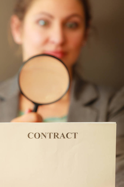Business woman with contract and loupe - Foto, Imagen