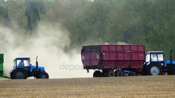 Combine removes harvest and pours grain into a tractor-trailer. - Footage, Video