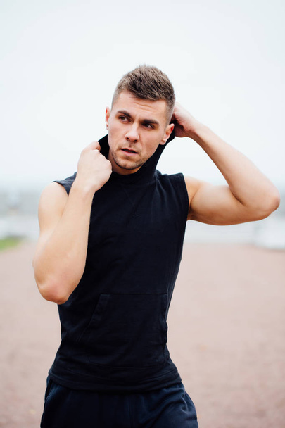 handsome young muscular sports man on city park background, posing, - Zdjęcie, obraz