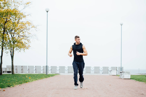 Athletic young man running in the nature. Healthy lifestyle - Fotoğraf, Görsel