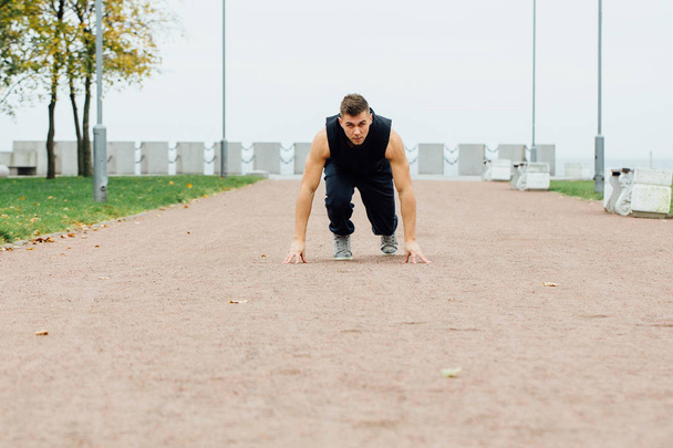 Fitness man training and jogging in fall park. Ready to start. Healthy lifestyle - Valokuva, kuva