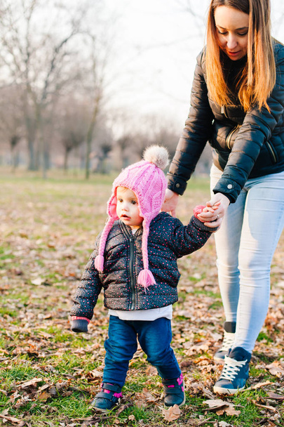 Маленькая девочка держит маму за руку и ходит
 - Фото, изображение