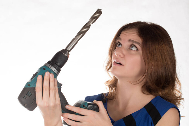 Девушка с отвёрткой рабочего инструмента смеётся над белой спиной
 - Фото, изображение