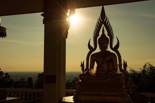 夕暮れには夕日を背景の寺で仏像のシルエット。Th - 写真・画像