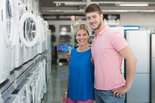 Beautiful Young Couple Shopping Washing Machine In Supermarket - Foto, imagen