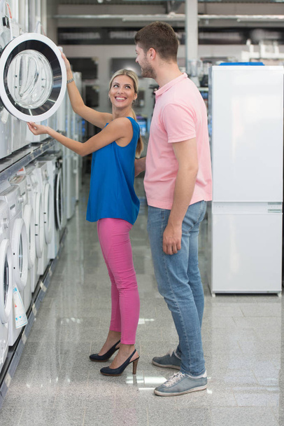 Beautiful Young Couple Shopping Washing Machine In Supermarket - Foto, Imagem