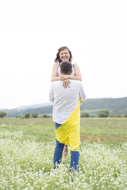 Lovers man and woman walk on the flower field. - Foto, imagen