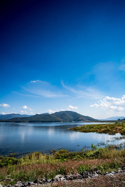 Lago con fondo de montaña y cielo azul
 - Foto, Imagen