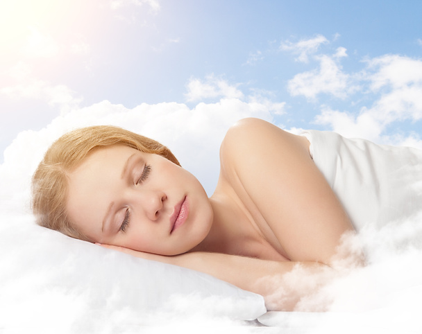 schöne junge Frau schläft auf einer Wolke am Himmel - Foto, Bild
