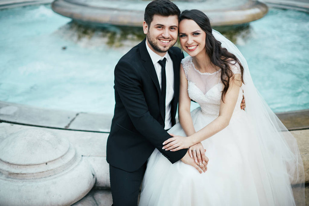 Beautiful couple sitting near fountain - Fotografie, Obrázek