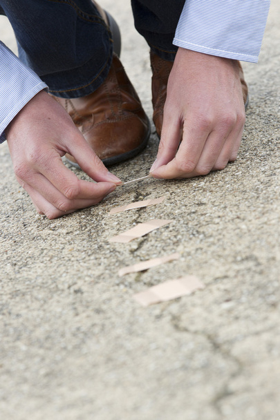 Man Applying Adhesive Bandage On Cracked Road. - Foto, Bild