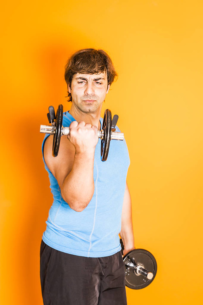 Homem adulto fazendo exercício com halteres em casa
 - Foto, Imagem