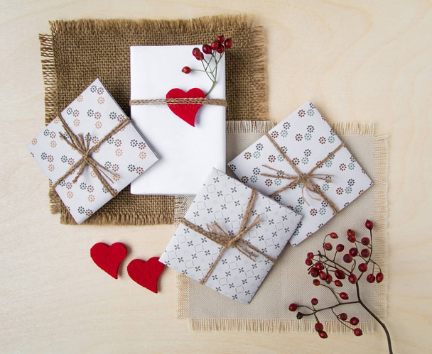 Rustic handmade gift boxes over wooden background. Top view, flat lay - 写真・画像