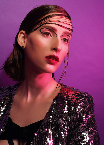 fashion model posing over purple background - Фото, изображение