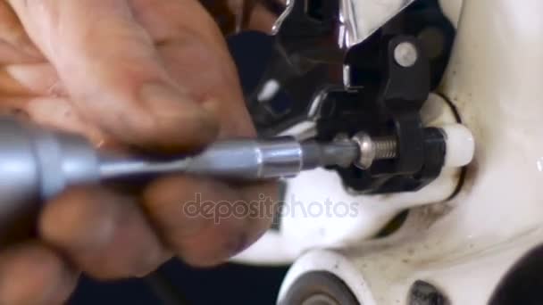 Bliska człowieka poluzowanie przerzutka na rowerze z śrubokręta - Materiał filmowy, wideo