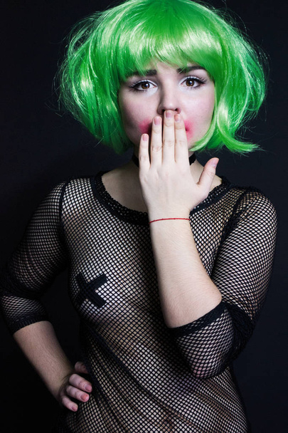 foto portret van een meisje in de jurk van grid met groene haren raakt zijn mond - Foto, afbeelding