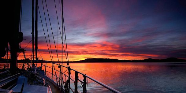 Crimson waterscape Sunrise z łodzi. - Zdjęcie, obraz