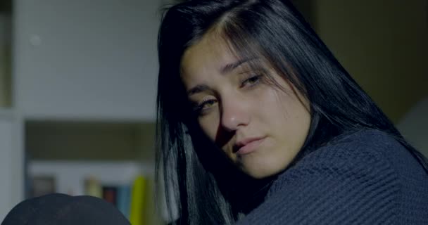 Beautiful young woman feeling sad at home at night - Filmati, video