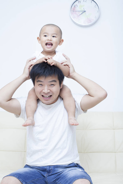 Père et fils chinois jouant dans le canapé
 - Photo, image