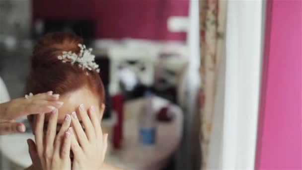 Frau in Gesichtsnähe mit Händen, die vor Haarspray aus nächster Nähe schützen. Friseur verwendet Haarspray, um Kunden elegante Frisur im Schönheitssalon zu reparieren  - Filmmaterial, Video