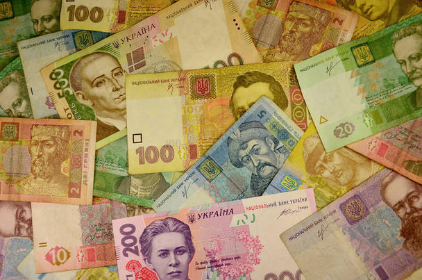 De achtergrondafbeelding van een stapel van Oekraïense bankbiljetten van verschillende waarden. Een groot aantal bankbiljetten van de Oekraïense bank, die de hryvnia worden genoemd. Het concept van de economische crisis in Oekraïne - Foto, afbeelding