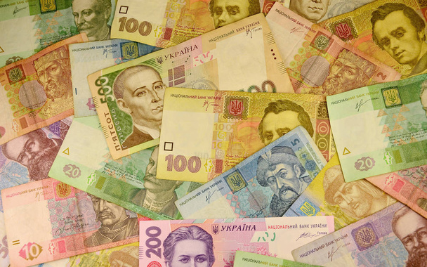 異なる値のウクライナの紙幣の山の背景イメージです。グリブナと呼ばれる、ウクライナの銀行の紙幣の膨大な数。Ukrain の経済危機の概念 - 写真・画像